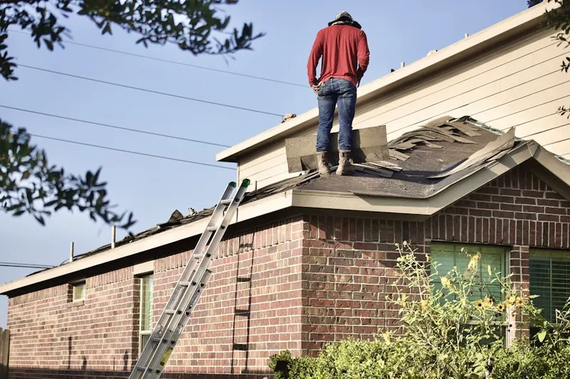 Professional roofer working on a residential roof in Delmont